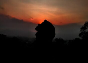 silhouette of person against sunset sky