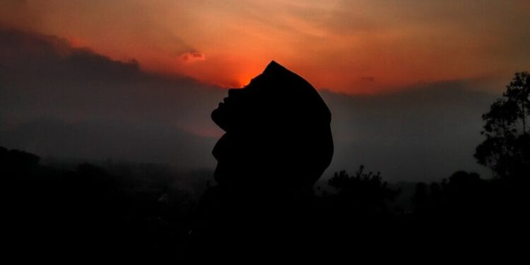 silhouette of person against sunset sky