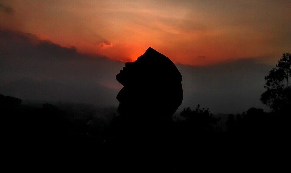 silhouette of person against sunset sky